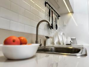 a kitchen counter with a sink and a bowl of apples at Bears Nook - Marina Spatial Dumaguete in Piapi +7 photos