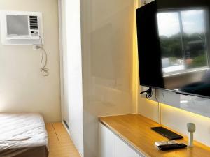a room with a bed and a television on a desk at Bears Nook - Marina Spatial Dumaguete in Piapi