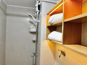 a bathroom with a shower and towels on a shelf at Bears Nook - Marina Spatial Dumaguete in Piapi