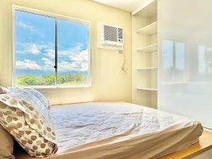 a bedroom with a bed and a window at Bears Nook - Marina Spatial Dumaguete in Piapi