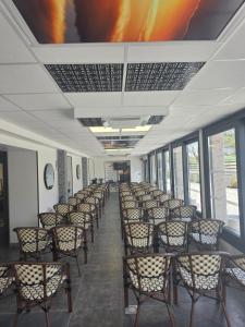 a row of chairs in a room with a painting on the ceiling at Hôtel De La Promenade in Chevigney
