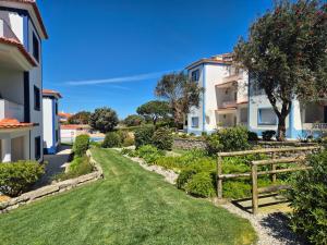 a garden with a fence and houses at Casa Arreyal in Amoreira