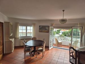 a dining room with a table and chairs and a balcony at Casa Arreyal in Amoreira