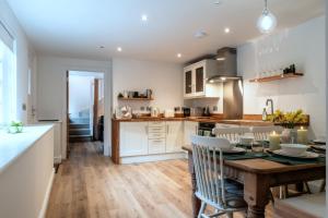 a kitchen with a wooden table and a dining room at Finest Retreats - Alpine Cottage in Symonds Yat