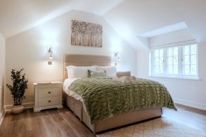 a white bedroom with a large bed and a window at Finest Retreats - Alpine Cottage in Symonds Yat