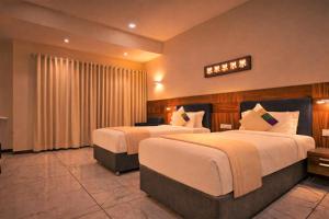 a hotel room with two beds and a television at Hotel Mandovin - A Premium Hotel In Udaipur in Udaipur