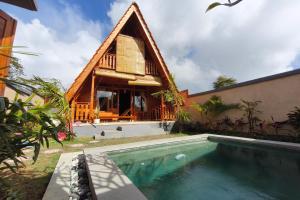 a house with a pool in front of a building at D'Cabin Villa Uluwatu in Uluwatu