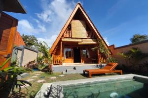 a house with a thatched roof and a swimming pool at D'Cabin Villa Uluwatu in Uluwatu