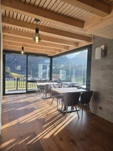 a dining room with tables and chairs and a large window at Résidence Bellevue - Hôtel et Studios in Charmey