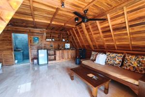 a living room with a couch and a ceiling fan at D'Cabin Villa Uluwatu in Uluwatu