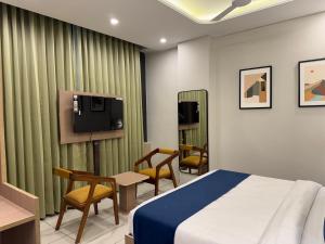 a hotel room with a bed and a tv at Hotel The Merc in Kharar
