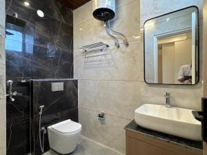 a bathroom with a sink and a toilet and a mirror at Hotel The Merc in Kharar