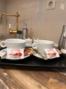 two cups and saucers sitting on a tray at Norderney Apartments in Sibiu +47 photos