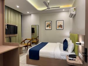 a hotel room with a bed and a desk at Hotel The Merc in Kharar