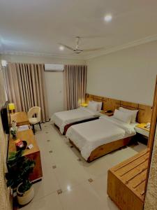 a hotel room with two beds and a table at The Mark in Islamabad
