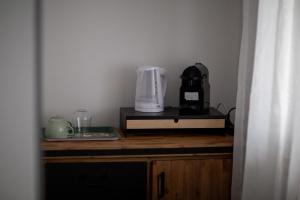 a kitchen with a counter with a coffee maker and a blender at Résidence Bellevue - Hôtel et Studios in Charmey