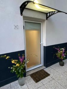 a glass door with flowers in vases on a building at Casa da Covilhã - Pedra e Lã in Covilhã