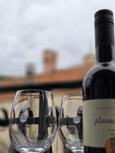 two wine glasses sitting next to a bottle of wine at Guesthouse Ivan in Skradin +53 photos