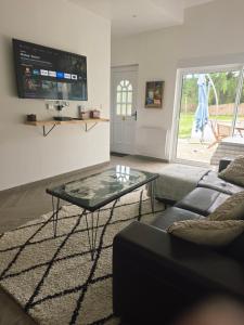 a living room with a glass table and a couch at Le Little cocoon in Durtol