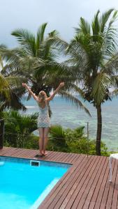 a girl standing on a deck near a swimming pool at South Point Villas Cerf Island in Cerf Island +48 photos