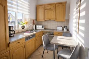a kitchen with wooden cabinets and a table with chairs at Ferienwohnung Czampiel in Havelberg