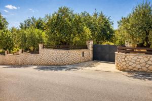 a stone fence with trees in the background at Dora Apartments in Tragaki +19 photos