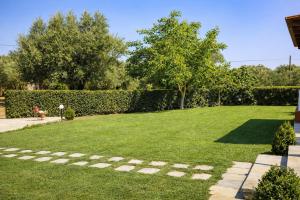 a large yard with a hedge and a grassy field at Dora Apartments in Tragaki