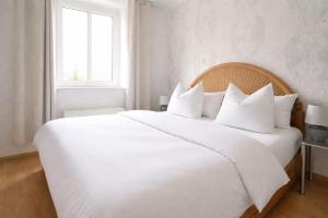 a white bed with white pillows and a window at Ferienwohnung Czampiel in Havelberg