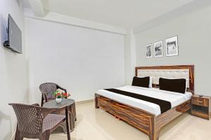 a bedroom with a bed and a table and a chair at Hotel o Skylight in New Delhi