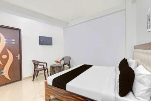a bedroom with a bed and a table and chairs at Hotel o Skylight in New Delhi
