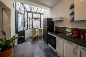 a kitchen with a black refrigerator and a table at Maison au cœur de Saumur Cour privée Parking gratuit Wi-Fi in Saumur