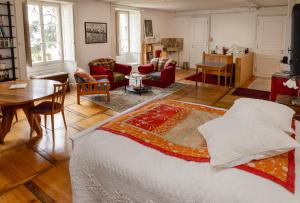 a living room with a bed and a table at B&B Château de Denens in Denens
