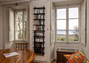 a room with a table and a book shelf with books at B&B Château de Denens in Denens