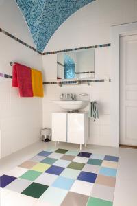 a bathroom with a sink and a colorful floor at B&B Château de Denens in Denens