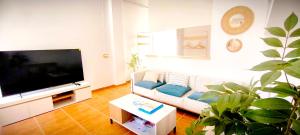 a living room with a couch and a flat screen tv at Casa Playa Moncofa in Moncófar