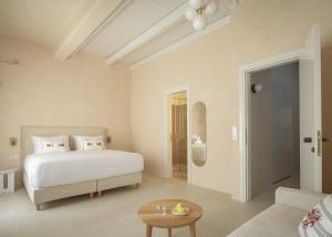 a white bedroom with a bed and a couch at Moshoviti Residence in Rethymno