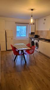 a kitchen with a table and four red chairs at Ella Apart Hotel in Constanţa +40 photos