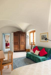 a living room with a green couch with red pillows at B&B Château de Denens in Denens +13 photos