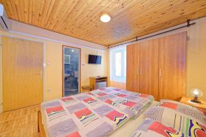 a bedroom with a bed and a wooden ceiling at Rooms Milica in Palit