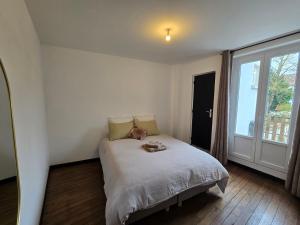 a bedroom with a bed and a large window at La Grande Glycine in Coulommiers
