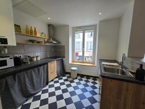 a kitchen with a sink and a checkered floor at La Grande Glycine in Coulommiers