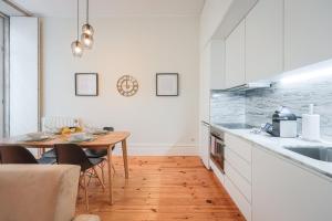 a kitchen with a table and a dining room at Aliados Town Hall Central Apt by LuxiStay in Porto