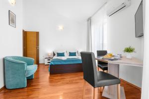 a bedroom with a bed and a table and a desk at LotusApart in Premantura