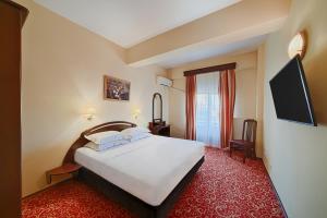a hotel room with a large bed and a red carpet at Hotel Central in Ploieşti