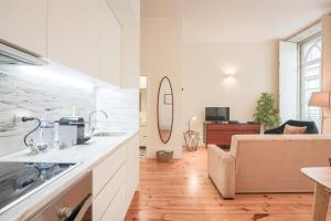 a kitchen and living room with a sink and a couch at Aliados Town Hall Central Apt by LuxiStay in Porto