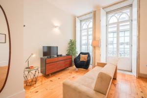 a living room with a couch and a tv at Aliados Town Hall Central Apt by LuxiStay in Porto