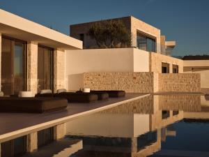 a house with a swimming pool next to a building at On The Rocks 7 Bedroom Villa in Koríthion