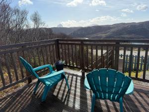 two chairs on a deck with a view of the mountains at Selkie Cabin Achmelvich, Lochinver in Lochinver +23 photos