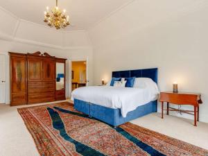 a bedroom with a blue bed and a wooden desk at 7 Bed in Dollar oc-88668 in Powmill