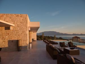 a resort with a pool and tables and chairs at On The Rocks 7 Bedroom Villa in Koríthion